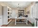 Home office featuring a large desk, built-in cabinets, and natural light from shuttered windows at 2156 Cheswick Ln, Mount Pleasant, SC 29466
