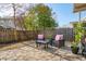 Landscaped backyard featuring a stone patio, wooden fence, mature tree coverage, and a cozy outdoor seating area at 225 Nelliefield Creek Dr, Wando, SC 29492