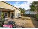 Backyard with a covered patio area with furniture, a stone patio, green lawn, and a wooden privacy fence at 225 Nelliefield Creek Dr, Wando, SC 29492