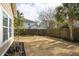 Backyard with a privacy fence, grass lawn, various trees and other vegetation, and exterior of neighboring homes at 225 Nelliefield Creek Dr, Wando, SC 29492