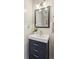 Stylish powder room features a navy vanity, modern lighting, and decorative mirror at 225 Nelliefield Creek Dr, Wando, SC 29492