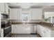 Bright kitchen features white cabinets, stainless steel appliances, and granite countertops at 225 Nelliefield Creek Dr, Wando, SC 29492