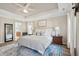 Comfortable main bedroom with tray ceiling featuring white and neutral decor and adjoining bathroom at 225 Nelliefield Creek Dr, Wando, SC 29492