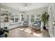 Bright sunroom with built-in bookshelves, window seat, and plush armchairs for relaxing at 225 Nelliefield Creek Dr, Wando, SC 29492