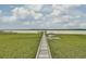 Picturesque aerial view of a wooden dock extending into the water, surrounded by lush green marshland at 2516 Willbrook Ln, Mount Pleasant, SC 29466