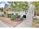 Manicured front yard with lush landscaping, brick-lined flowerbeds, and a charming staircase leading to the porch at 2516 Willbrook Ln, Mount Pleasant, SC 29466