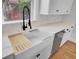 Close-up of a white farm sink with black faucet and built-in accessories in a bright kitchen at 2516 Willbrook Ln, Mount Pleasant, SC 29466