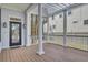Spacious porch with white columns, wood flooring, and a view of the surrounding neighborhood at 2516 Willbrook Ln, Mount Pleasant, SC 29466