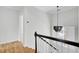 Staircase with a modern light fixture and white risers, complemented by wood treads at 2516 Willbrook Ln, Mount Pleasant, SC 29466