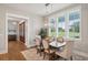 Elegant dining room with modern chandelier, wood table, and large window at 2621 Anchor Watch Dr, Wadmalaw Island, SC 29487