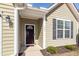 Close up of the front door, with sidelight window, olive siding, and black shutters at 322 Freeland Way, Moncks Corner, SC 29461