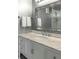 Close-up of a vanity with marble counters, chrome hardware, and a decorative mirror at 330 Concord St # 14 A, Charleston, SC 29401