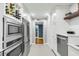 Kitchen with stainless steel appliances, wine rack, and view of a hallway with decorative wallpaper at 330 Concord St # 14 A, Charleston, SC 29401