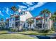 Condo exterior with balconies, palm trees, well-maintained landscaping, and inviting walkways at 401 Yacht Harbor Ct, Isle of Palms, SC 29451