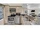 Well-equipped kitchen featuring stainless steel appliances and granite countertops, seamlessly flowing into the living area at 401 Yacht Harbor Ct, Isle of Palms, SC 29451
