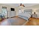 Comfortable main bedroom featuring hardwood floors, a ceiling fan, and ample natural light from the window at 401 Yacht Harbor Ct, Isle of Palms, SC 29451