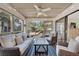 Inviting sunroom with comfortable seating, ceiling fan, and string lights, offering a relaxing view of the outdoors at 401 Yacht Harbor Ct, Isle of Palms, SC 29451
