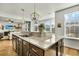 Spacious kitchen island with a sink, granite countertops, and dark wood cabinets, with a view to living room at 402 Spectrum Rd, Summerville, SC 29486