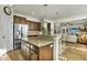 Open-concept kitchen with island, stainless steel refrigerator, wood floors, and seamless flow to the living area at 402 Spectrum Rd, Summerville, SC 29486