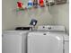 Functional laundry room featuring white washer and dryer units with shelving above at 402 Spectrum Rd, Summerville, SC 29486