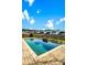 Backyard pool is surrounded by a brick patio and lush landscaping with a view of the neighborhood at 402 Spectrum Rd, Summerville, SC 29486