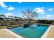 Stunning in-ground pool features a brick surround, waterfall feature, and backyard views of the neighborhood pond at 402 Spectrum Rd, Summerville, SC 29486