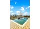 Backyard pool is surrounded by a brick patio and lush landscaping with a view of the lake and neighboring houses at 402 Spectrum Rd, Summerville, SC 29486