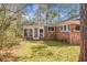 Quaint brick home exterior with sunroom, and a spacious backyard covered in seasonal foliage at 407 Hayne St, Walterboro, SC 29488
