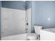 Clean bathroom showcases a white tub-shower combo and toilet against blue walls at 407 Hayne St, Walterboro, SC 29488