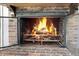 Rustic brick fireplace featuring an ornate metal grate and a robust fire burning inside at 407 Hayne St, Walterboro, SC 29488