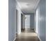 Long hallway with neutral blue walls, white trim, and multiple doors leading to other rooms at 407 Hayne St, Walterboro, SC 29488