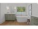 Bright bathroom featuring a soaking tub, modern vanity, and light wood flooring at 499 Lackland Ct, Mount Pleasant, SC 29464