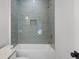 Close-up of a gray subway tiled shower with gold fixtures, complemented by a bright white tub and walls at 499 Lackland Ct, Mount Pleasant, SC 29464