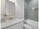 Modern bathroom with gray subway tile in shower, gold fixtures, white vanity, and decorative gold-framed mirror at 499 Lackland Ct, Mount Pleasant, SC 29464