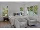 Light-filled bedroom with two armchairs, a comfortable bed, and views of the outdoors through multiple windows at 499 Lackland Ct, Mount Pleasant, SC 29464