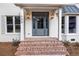 Inviting front porch with brick steps, stylish gray door, and decorative lanterns for a warm welcome at 499 Lackland Ct, Mount Pleasant, SC 29464