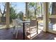 Screened-in porch dining area featuring a modern table and chairs, with views of the lush backyard at 499 Lackland Ct, Mount Pleasant, SC 29464