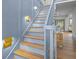 Charming staircase with wood treads, blue risers, and modern gold sconces, leading to an inviting foyer at 499 Lackland Ct, Mount Pleasant, SC 29464