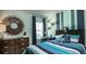A bedroom with modern accents, striped wall, wood dresser, and a bed with vibrant bedding at 546 Richfield Way, Summerville, SC 29486
