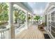 Spacious back porch with wooden floors, white columns, and an outdoor dining table at 5991 Joseph Blake Ln, Wadmalaw Island, SC 29487