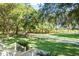 Expansive backyard with lush greenery, mature trees, and a charming white fence at 5991 Joseph Blake Ln, Wadmalaw Island, SC 29487