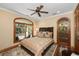 This bedroom features an arched window with natural light and a ceiling fan at 5991 Joseph Blake Ln, Wadmalaw Island, SC 29487