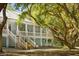 Picturesque home featuring a screened in porch, wooden stairs, and mature trees at 5991 Joseph Blake Ln, Wadmalaw Island, SC 29487