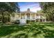 Beautiful two-story home with a stone chimney and a wrap-around porch, perfect for outdoor living at 5991 Joseph Blake Ln, Wadmalaw Island, SC 29487