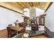 Open living room with vaulted ceilings, hardwood floors, stone fireplace and a table set for dining at 5991 Joseph Blake Ln, Wadmalaw Island, SC 29487