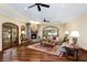 Bright and airy living room with a stone fireplace, hardwood floors, and lots of windows at 5991 Joseph Blake Ln, Wadmalaw Island, SC 29487
