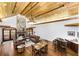 Open living room with hardwood floors, stone fireplace, vaulted wood ceilings, and a bar area at 5991 Joseph Blake Ln, Wadmalaw Island, SC 29487