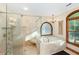 This bathroom features a glass shower, soaking tub, natural light, and chandelier at 5991 Joseph Blake Ln, Wadmalaw Island, SC 29487