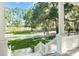 Picturesque view from the porch overlooking a grassy pasture with mature trees and a white fence at 5991 Joseph Blake Ln, Wadmalaw Island, SC 29487