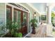 Inviting covered porch featuring stylish wood flooring, decorative plants and a charming exterior light at 5991 Joseph Blake Ln, Wadmalaw Island, SC 29487